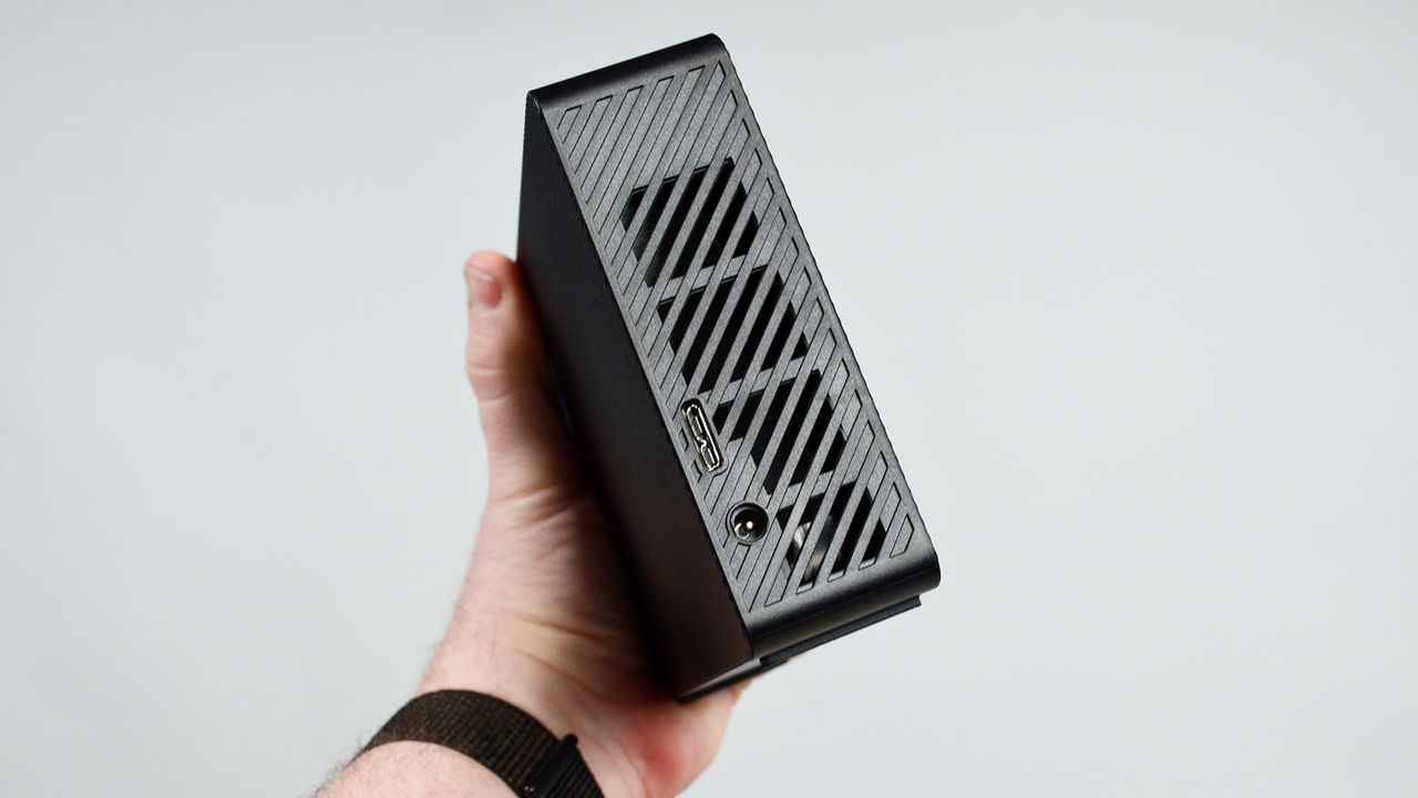 A masculine hand holding a Seagate Expansion external desktop hard drive
