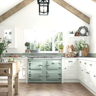 white kitchen with beams and sage green range cooker