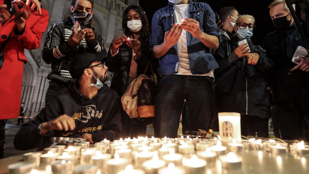 Mourners light candle outside the Notre-Dame de l'Assomption Basilica in Nice after a knife attack kills three