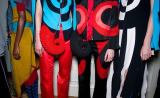 Backstage view of accessories featuring red and black bags at Kiko Kostadinov S/S 2020