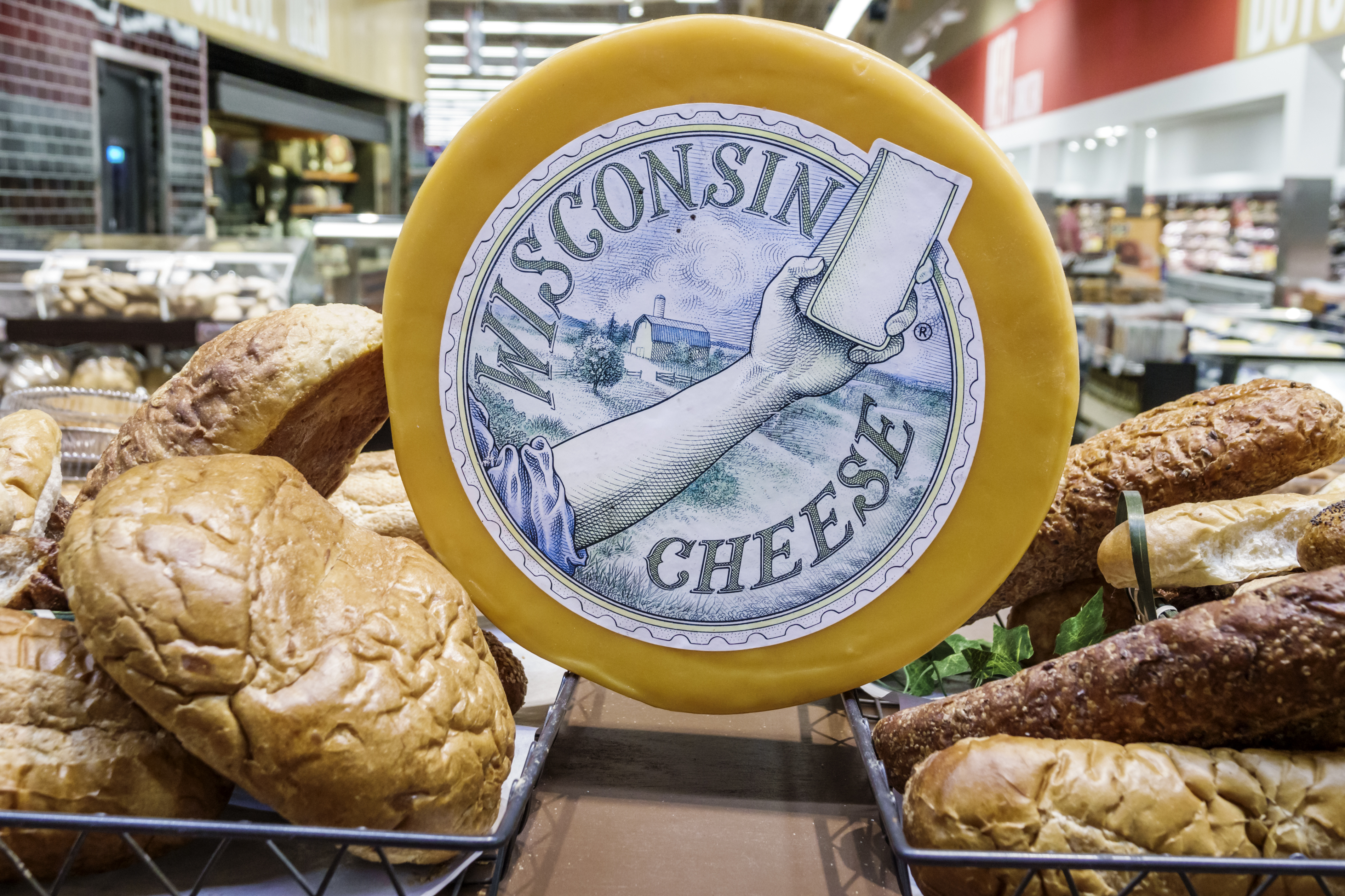A wheel of Wisconsin cheese inside a grocery store