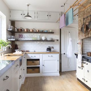 kitchen area with white wall and white wall tiles with white cabinet and wooden flooring