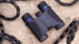 Zeiss Terra ED Pocket binoculars with coiled rope on ground