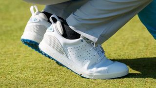 adidas flopshot golf shoes and their all white colorway contrasted against their blue sole design