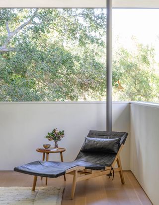 A bedroom corner with a chaise lounger chair