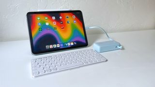 The Anker A1637 portable charger plugged into an iPad on a white table with a wireless keyboard