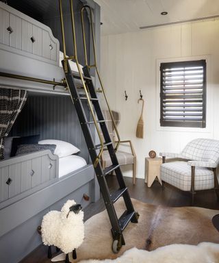 A bedroom with double bunk loft beds painted gray and a sheep statue