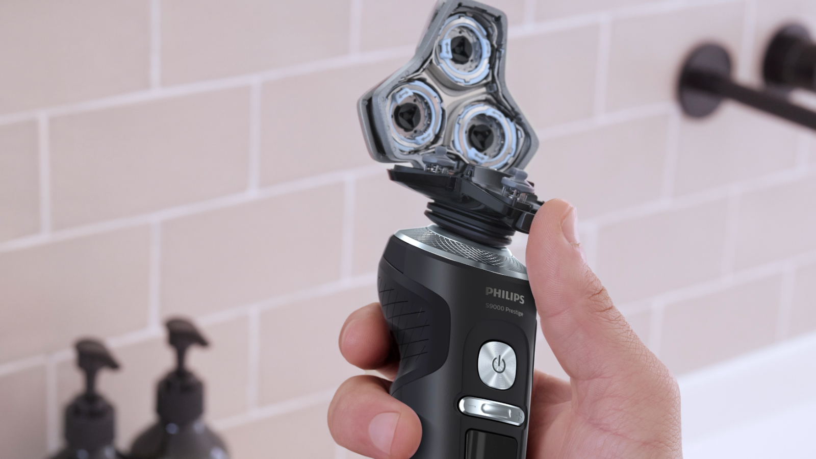 A hand holding the Philips Series 9000 Prestige shaver