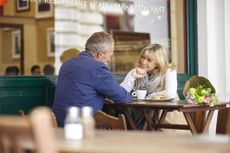 Mature dating couple chatting together at sidewalk cafe table - stock photo