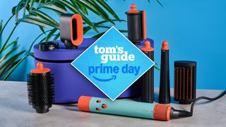 Dyson Airwrap i.d. along with box and attachments photographed in front of a blue background