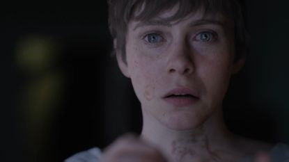 A screenshot of a woman with tears in her eyes in the OD trailer.