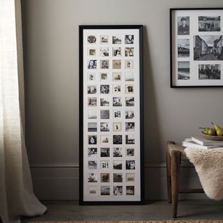 Multi-aperture frame with lots of black and white photos leaning against a wall