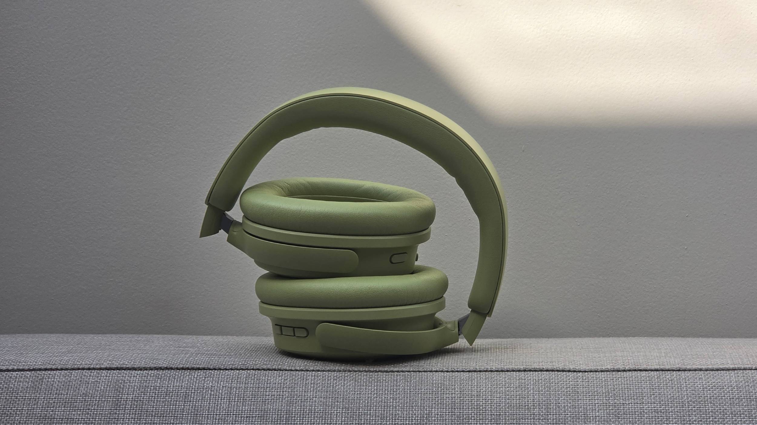 The Bose QuietComfort Headphones (2nd Gen) stacked on the back of a sofa.