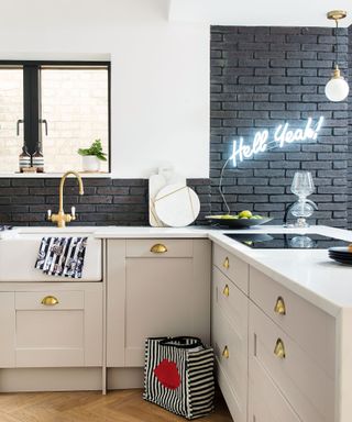 kitchen area with brick wall and cabinets with neon light on wall