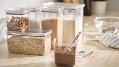A set of IKEA KORALLVIPPA food containers on a counter filled with dried pantry goods