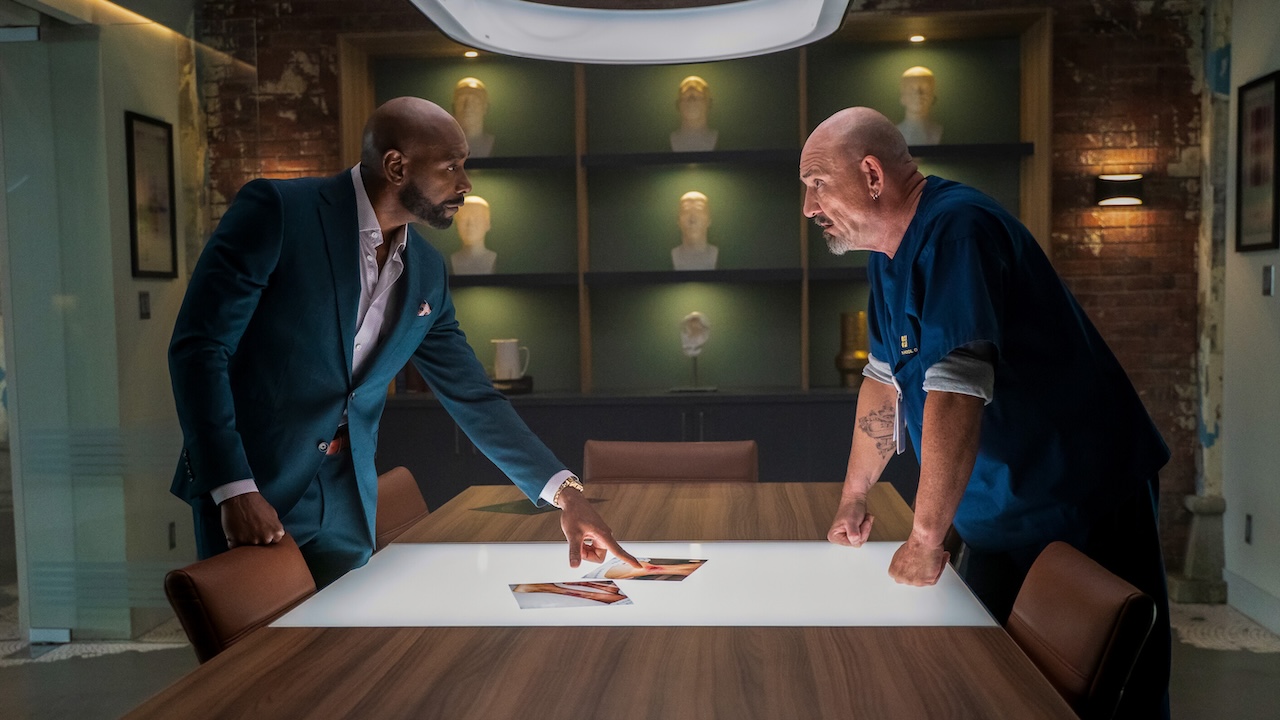 John and Shinwell looking at photos for a case in Watson Season 2x04