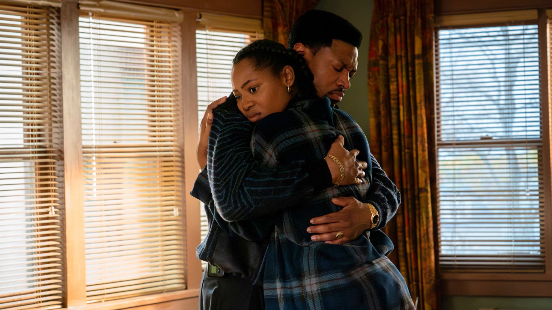 A man and a woman embrace in an empty room