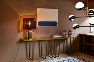 A wall breakfast bar featuring a lamp with a square clear shade, two vases and a lamp with multiple arms that have black and white balls at the end of each arm.