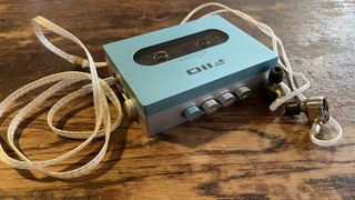 FiiO CP13 and headphones on a wooden antique table