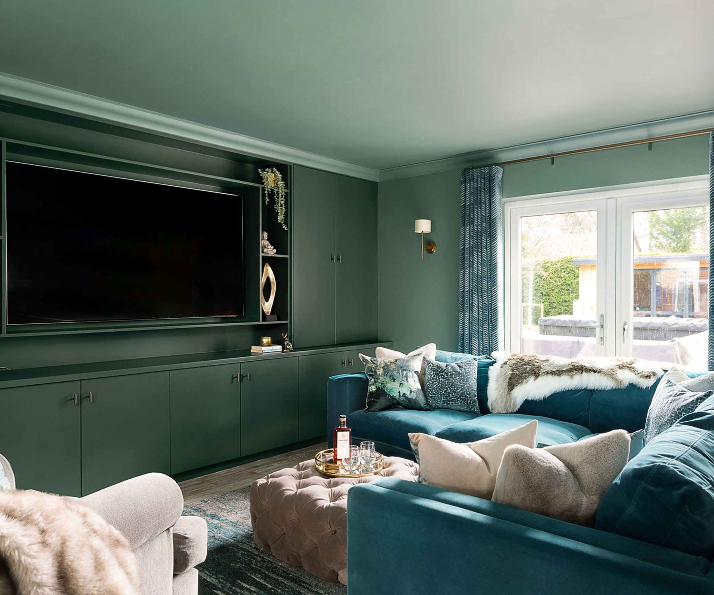 green colour drenched living room with teal velvet corner sofa