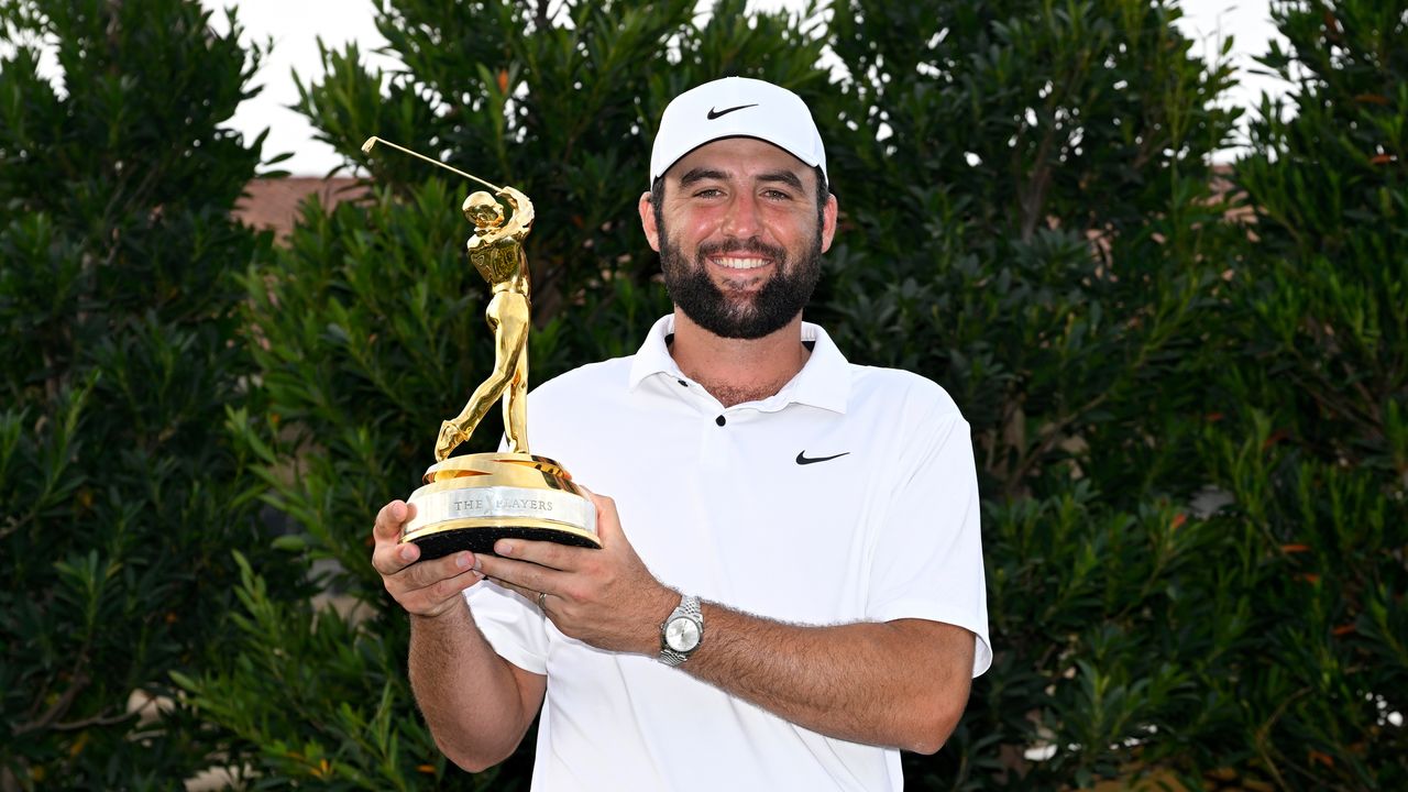 Scottie Scheffler holds up The Players Championship trophy after winning in 2024