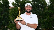 Scottie Scheffler holds up The Players Championship trophy after winning in 2024