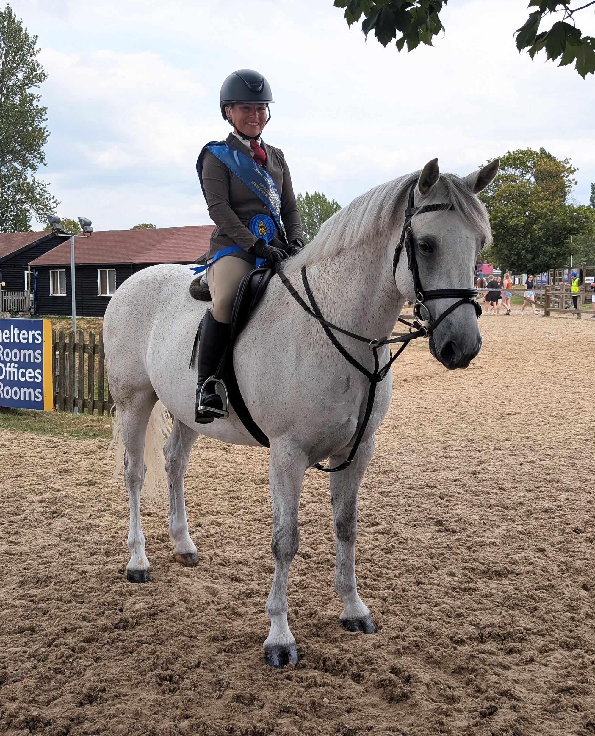 A grey native working hunter pony with rider on board wear the blue winner&amp;rsquo;s sash and rosette