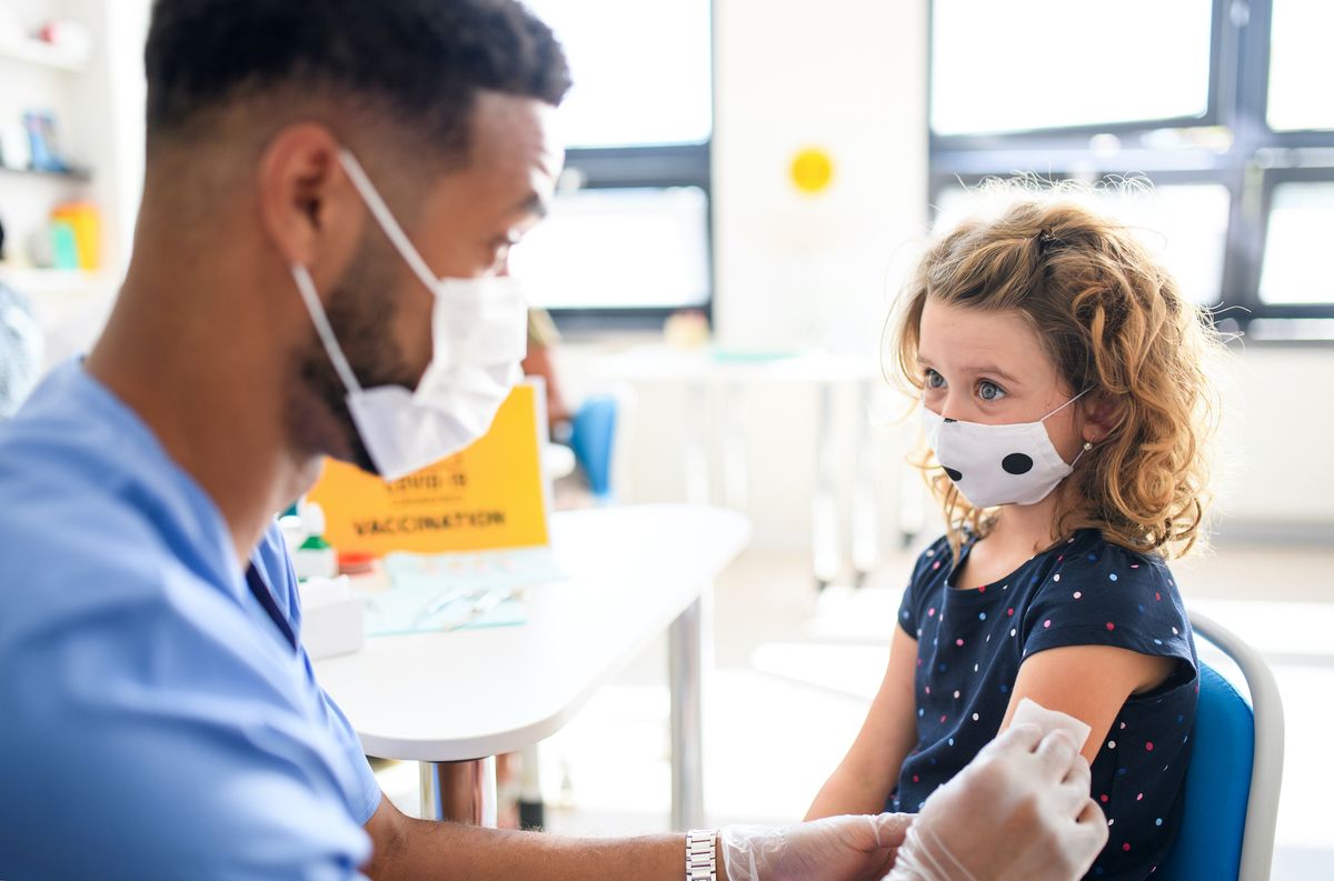 A healthcare worker vaccinates a young child.