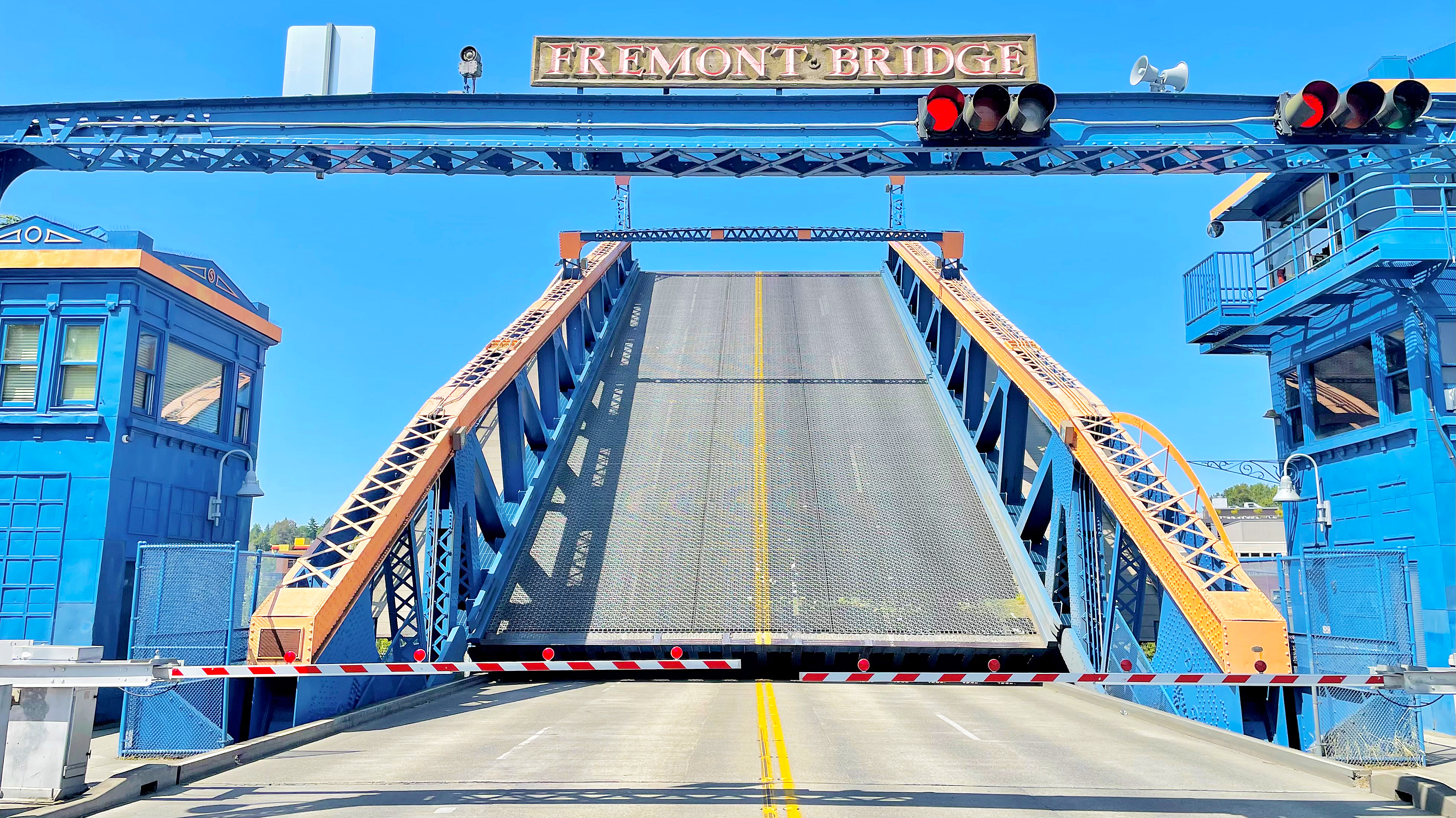 A view of the Fremont Bridge in Seattle from the roadway with the bridge starting to go up to let boat traffic through below
