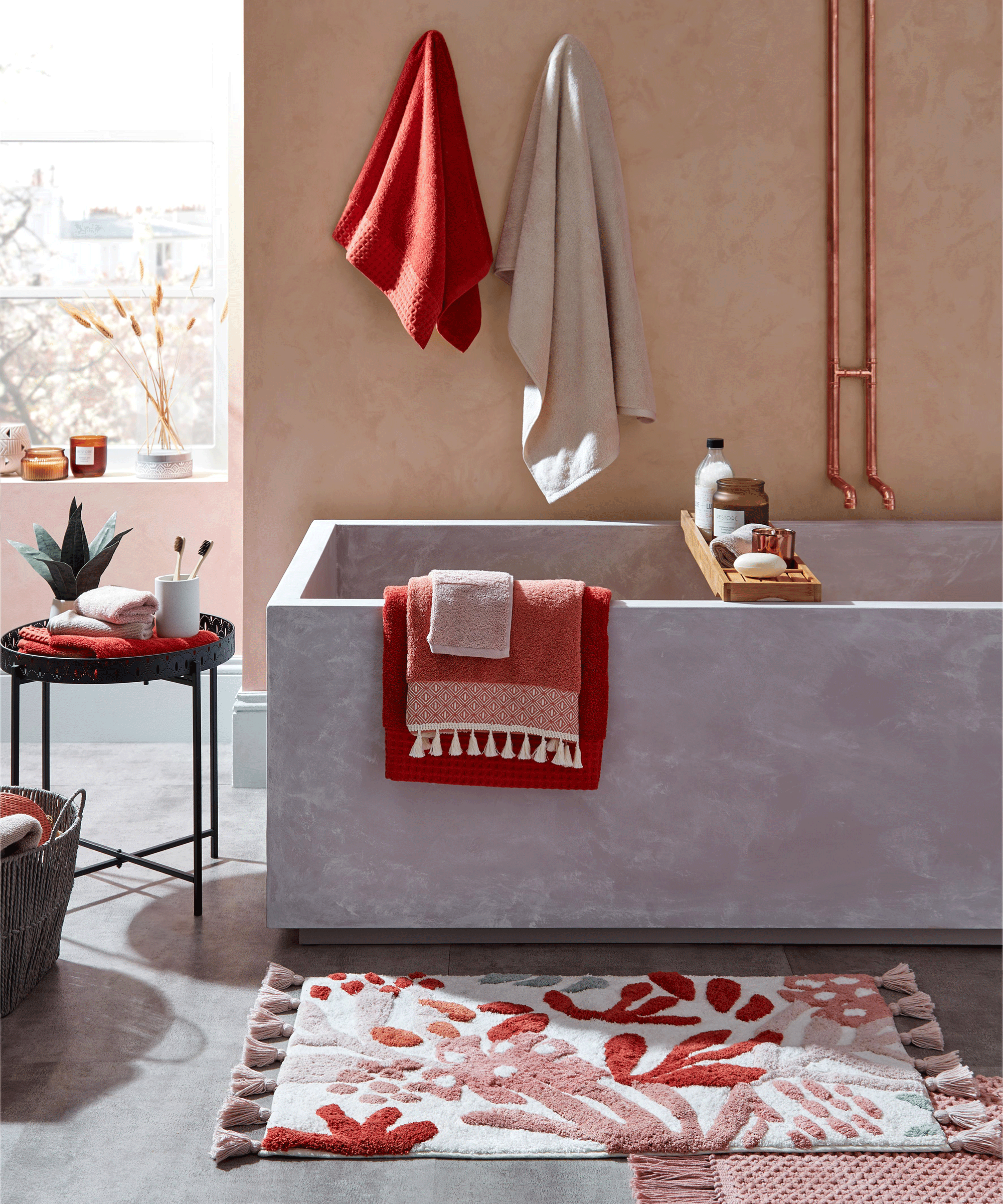 Bohemian bathroom with concrete bath and red/cream soft furnishings
