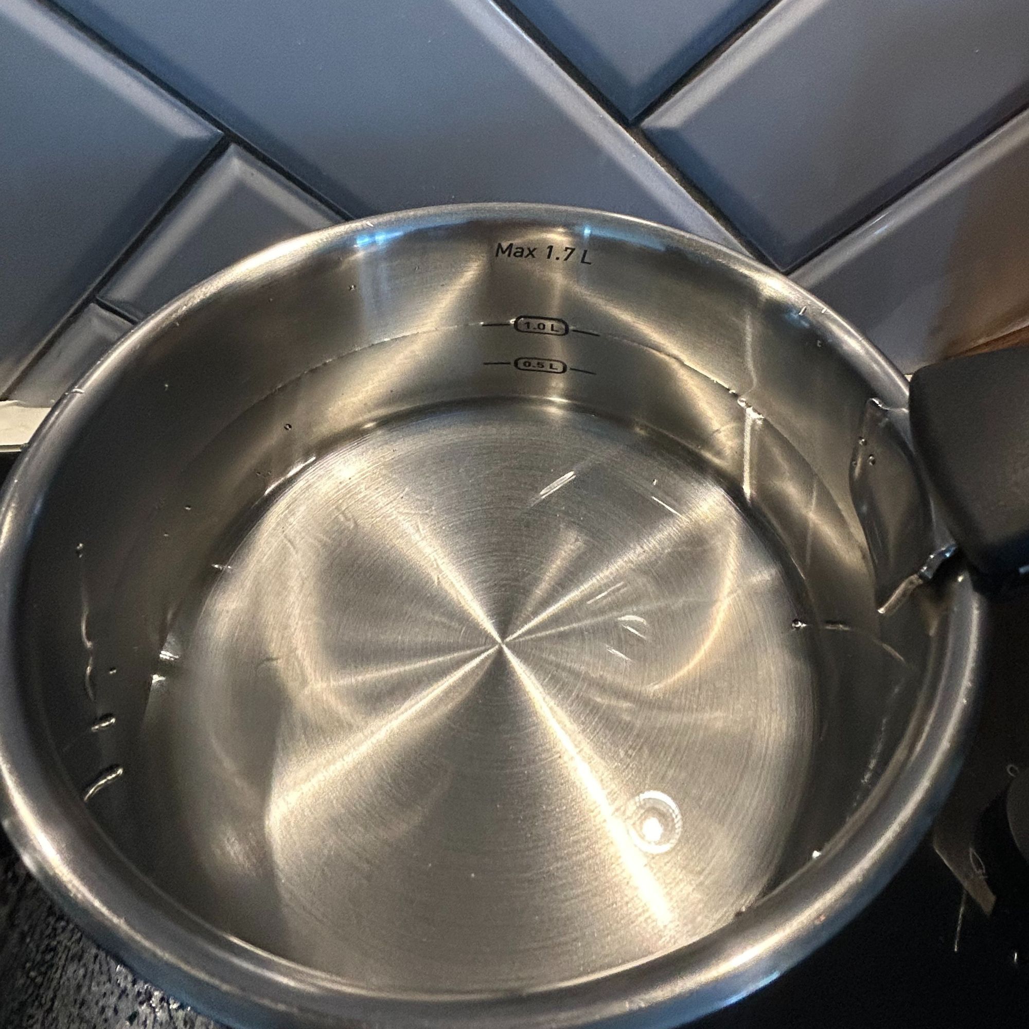Tefal Ingenio Emotion 22-Piece Pan Set close up with water inside, displaying measurements