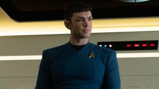 Ethan Peck as Spock on Star Trek: Strange New Worlds sitting behind a table