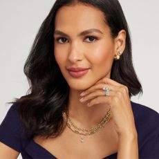 Young woman wearing navy top and gold and silver necklaces and earrings