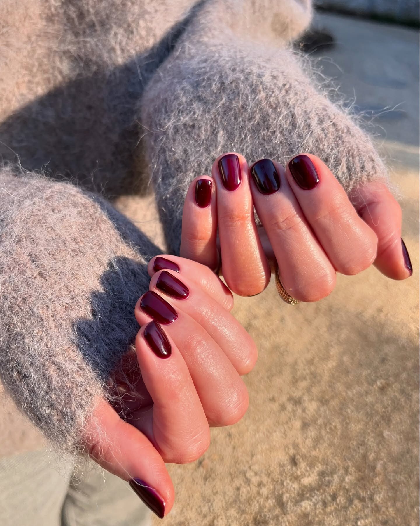 A short, rounded aubergine manicure