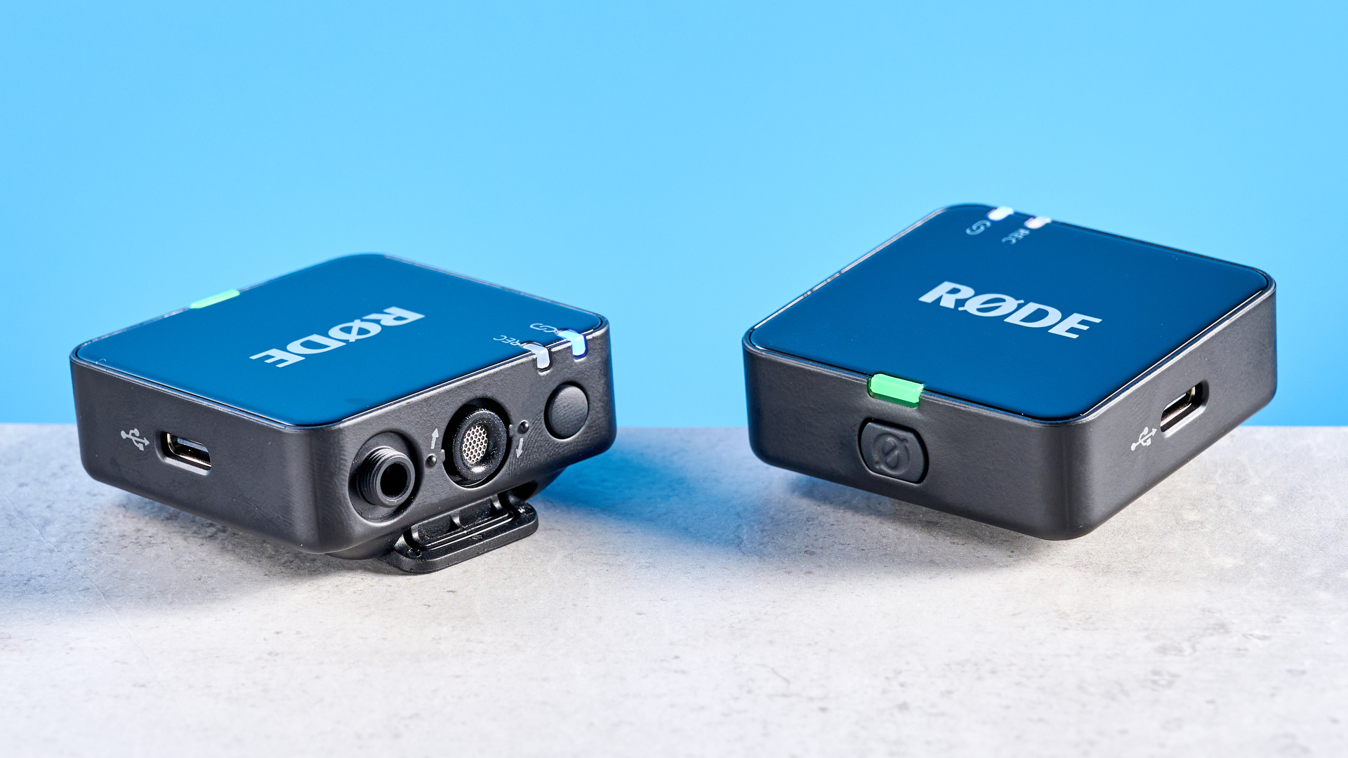 the rode wireless go gen 3 microphone with one receiver, two transmitters, shown against a blue background and with accessories like dead cat, charging ports, and cables