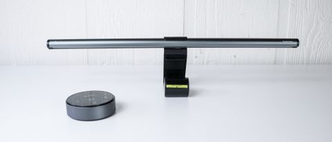 Quntis RGB Pro+ monitor light bar and its remote control on a table