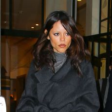 Jenna Ortega wearing a black coat and jeans