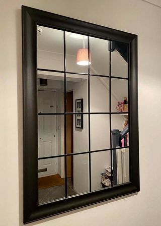 white room with black frame window mirror