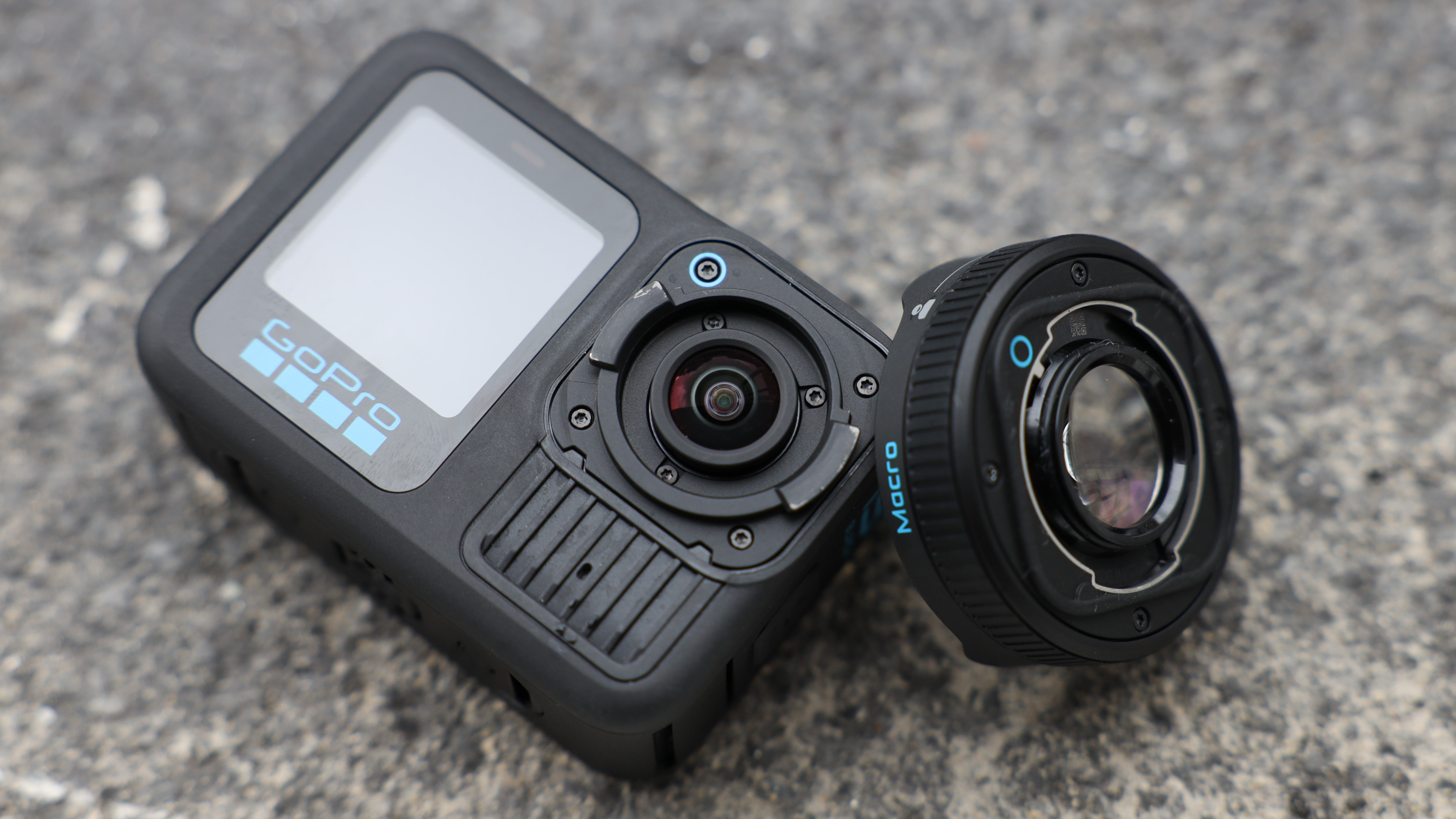 GoPro HERO13 Black action camera next to a lens on a dark surface