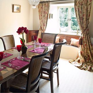 dinning room with cream colour wall brown dinning table and chairs and window and curtain