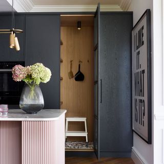 tall black cabinets with pink breakfast bar and a vase with flowers