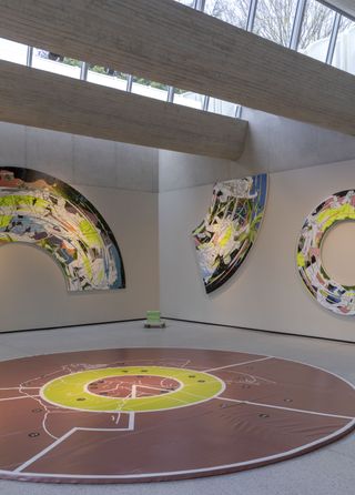 Inside the centre, which features a brown circular shaped mat on the floor and semi-circle art pieces on the wall.