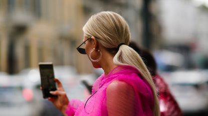 A guest wears earrings, sunglasses, a pink lace mesh dress, outside the Peter Pilotto show during Milan Fashion Week Spring/Summer 2020 on September 18, 2019 in Milan, Italy