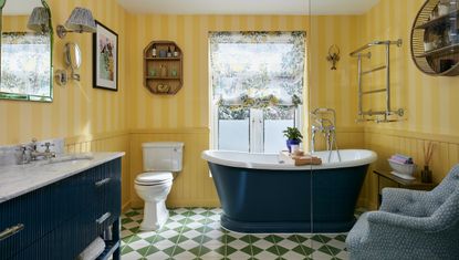 yellow bathroom with freestanding bath and flouncy blinds, an armchair and white loo