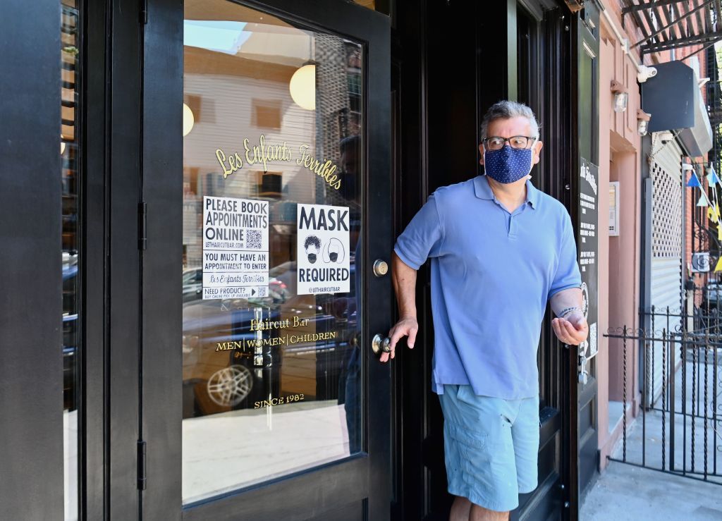 A man wears a mask after getting a haircut.