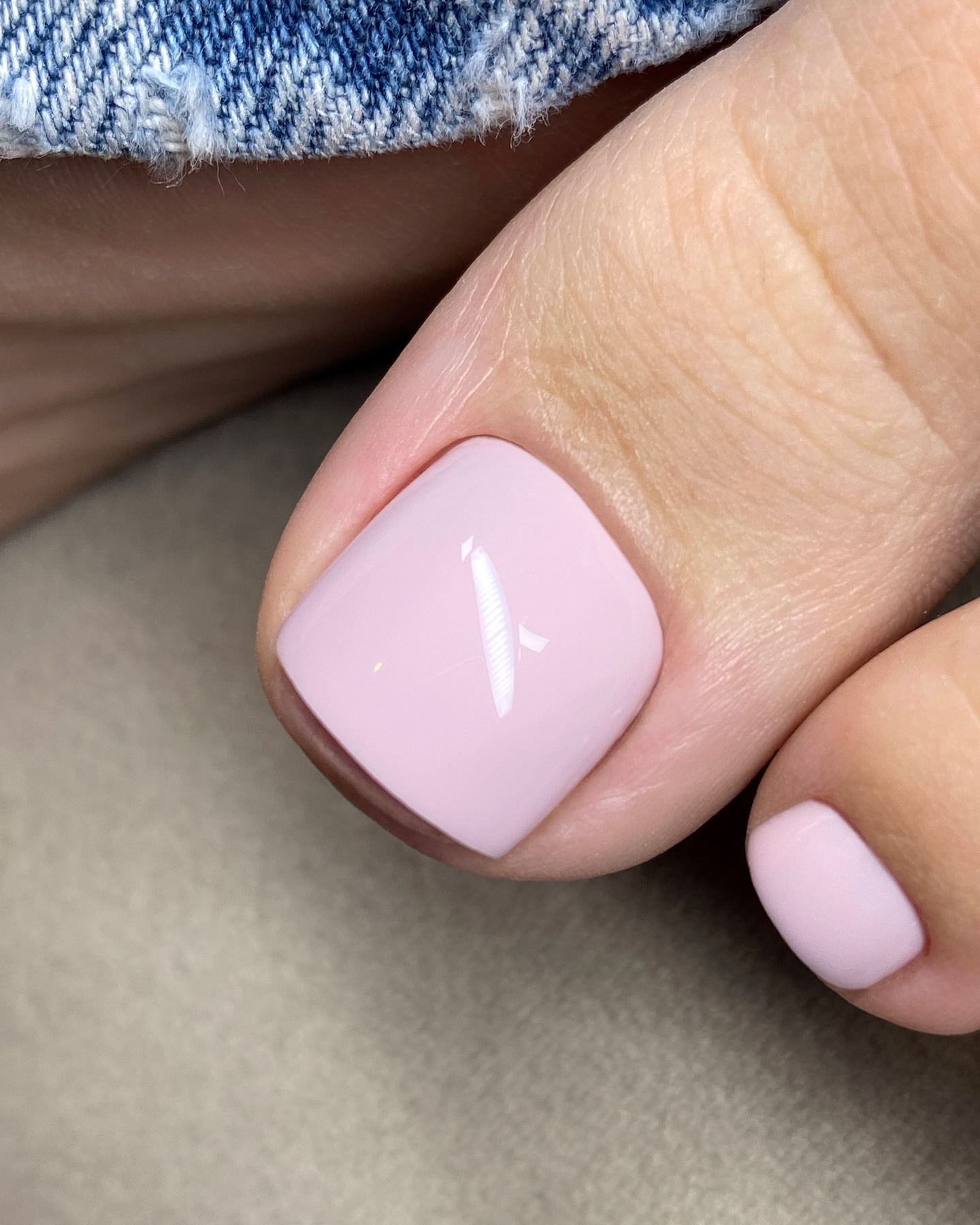 Uma foto em close da pedicure rosa bebê de uma mulher