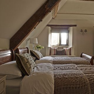 guest bedroom with exposed beams and cosy woollen throws