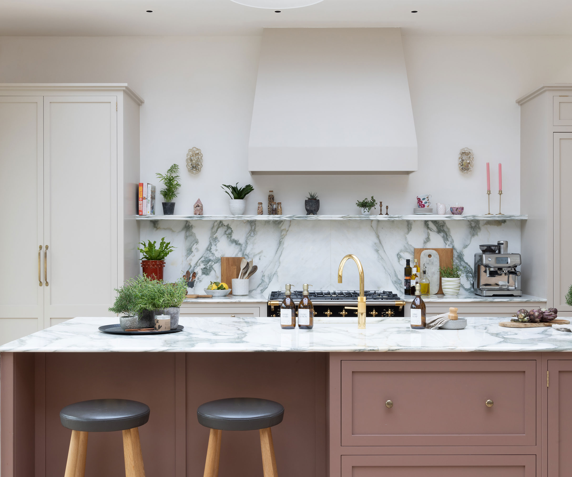 pink kitchen with open shelving and large island unit with sink