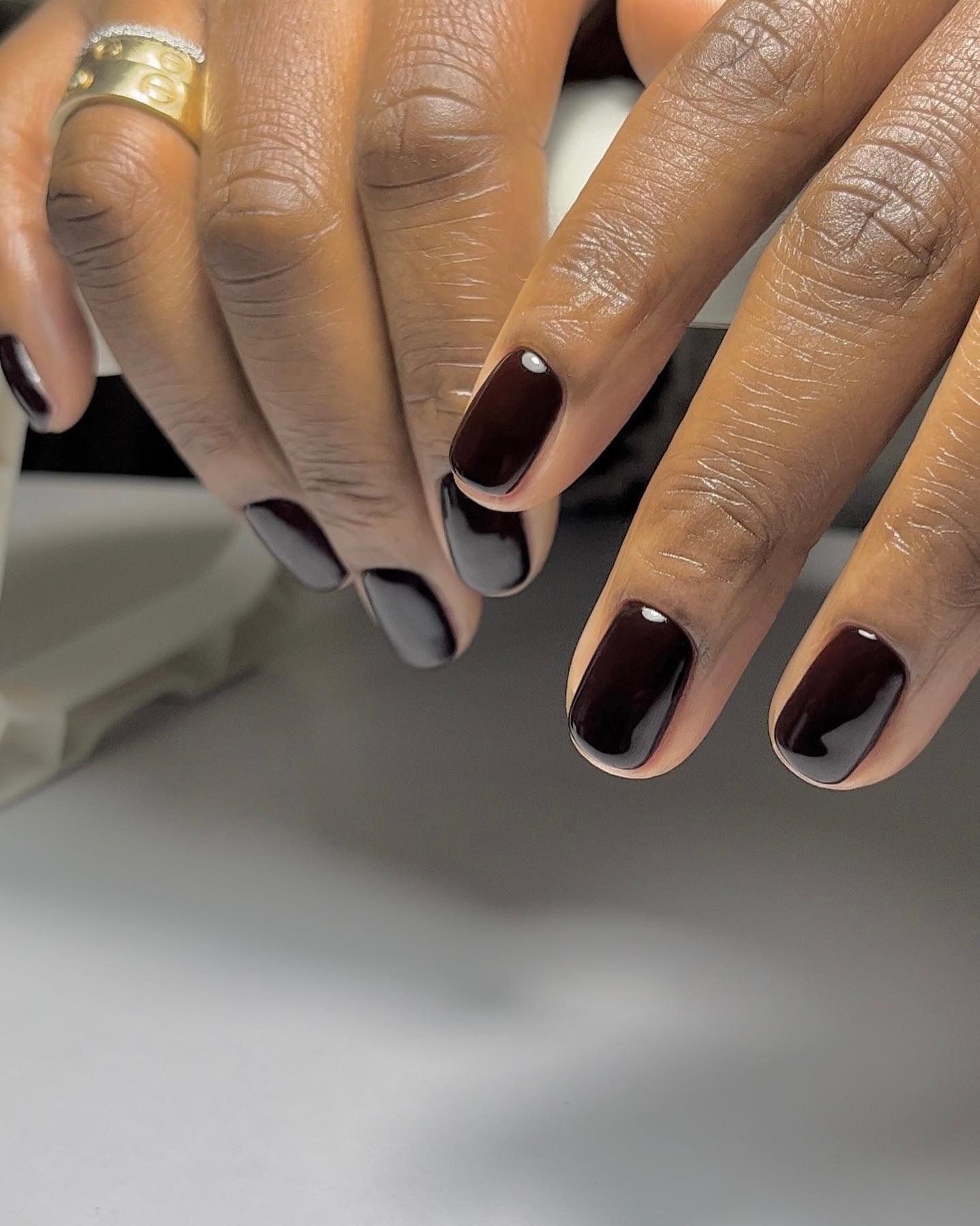 Short dark red-brown nails with gold rings