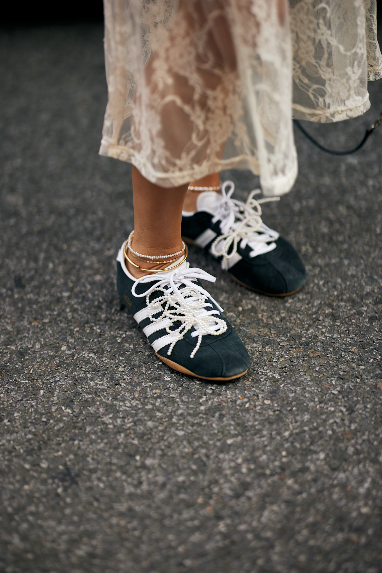 woman wearing a lace skirt and adidas sneakers
